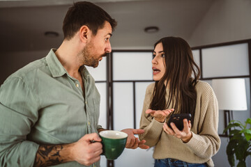 Jealous man spying his wife mobile phone while she is reading message
