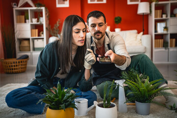 couple do gardening and take a photo of home plant with mobile phone