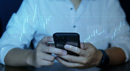 A businessman holding a smartphone with graph stock, Stock investment.