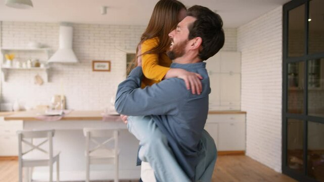 Carefree Caucasian girl running to happy parent man at home cheerful child embracing father family little kid guy laughing together bonding schoolgirl hug dad male holding daughter parenthood custody