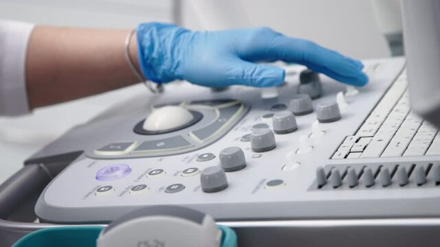 The hands of an ultrasound diagnostician on the control panel of an ultrasound machine during the examination. The concept of modern technology and advanced methods in medical imaging.