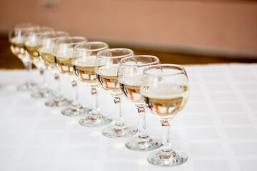 Obraz premium Sophisticated Row of Wine Glasses on White Tablecloth