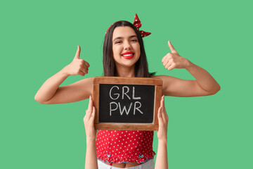 Beautiful young pin-up woman showing thumbs-up gesture and hands holding blackboard with text GIRL...