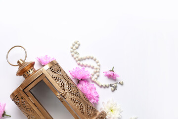 Muslim lamp with flowers and tasbih on white background. Ramadan celebration