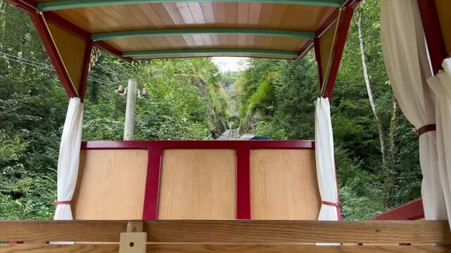 Beautiful POV ride on the historic Reichenbachfall-Bahn funicular in the Swiss Alps. Experience stunning alpine views as the vintage wooden carriage ascends towards the iconic Reichenbach Falls