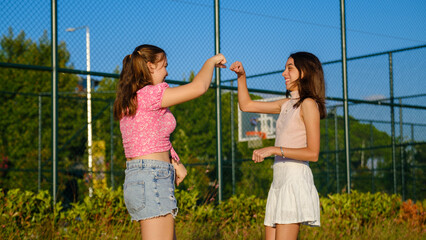 Two teenage girls friends, one slightly overweight and the other with dark skin, having a great...