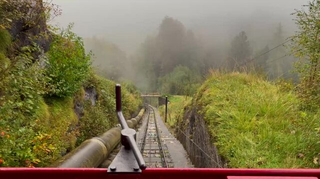 Beautiful POV ride on the historic Reichenbachfall-Bahn funicular in the Swiss Alps. Experience stunning alpine views as the vintage wooden carriage ascends towards the iconic Reichenbach Falls