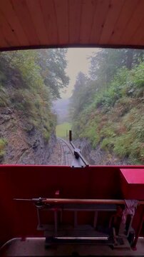 Beautiful POV ride on the historic Reichenbachfall-Bahn funicular in the Swiss Alps. Experience stunning alpine views as the vintage wooden carriage ascends towards the iconic Reichenbach Falls