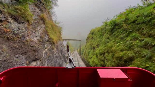 Beautiful POV ride on the historic Reichenbachfall-Bahn funicular in the Swiss Alps. Experience stunning alpine views as the vintage wooden carriage ascends towards the iconic Reichenbach Falls