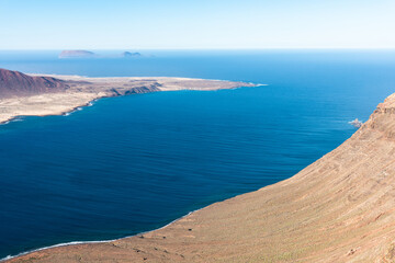 Aerial panoramic view of the volcanic island La Graciosa north cape coast, in Atlantic ocean, from Mirador del Rio, Lanzarote, Canary Islands, Spain. Travel concept.