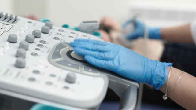 The hands of an ultrasound diagnostician on the control panel of an ultrasound machine during the examination. The concept of modern technology and advanced methods in medical imaging.
