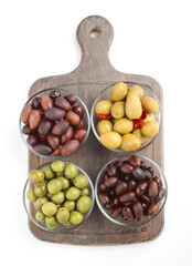 Variety of olives displayed in glass bowls on a wooden board