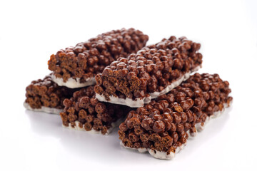 Crunchy chocolate snack bars stacked neatly on a white background for a tasty treat