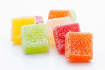 Colorful gummies arranged on a white surface with vibrant hues and sugary texture