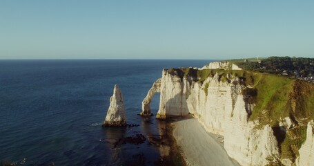 Panoramic view of the picturesque rocky mountains with a natural arch and a chalk peak sticking out of the water separately, on the banks of the English Channel. Etretat, France. 4k video, red komodo