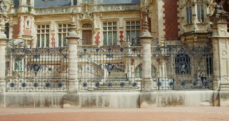 A young woman uses a smartphone while walking through a beautiful European city passing by the...