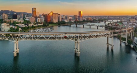 Fototapeta premium Aerial view of the Marquam Bridge over the Willamette River at sunrise, Portland, OR. City skyline and traffic visible. Portland, Oregon, USA