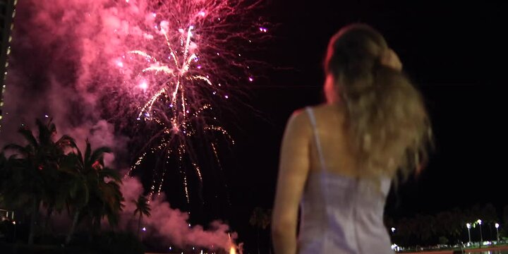 A woman watching close on a fireworks, anamorphic lens