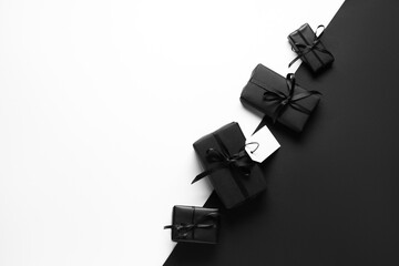 Gift boxes with blank paper tag on color background. Black Friday sale