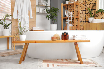 Bench and bathtub in interior of modern bathroom