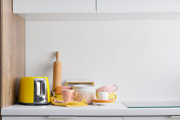 Toaster, rolling pin and dishes on counter against white background. Closeup