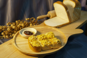 Toasted Bread with Savory Topping and Jam on Wooden Plate