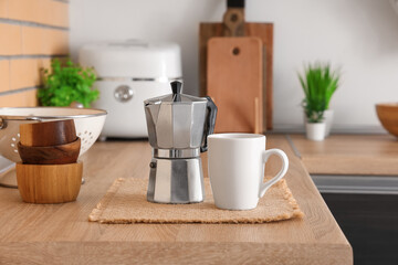 Coffee maker and mug on table in kitchen, closeup