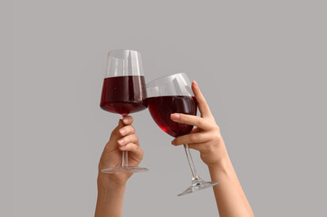 Female hands with glasses of red wine on white background