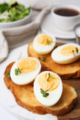 Sandwiches with hard boiled eggs on white table, closeup