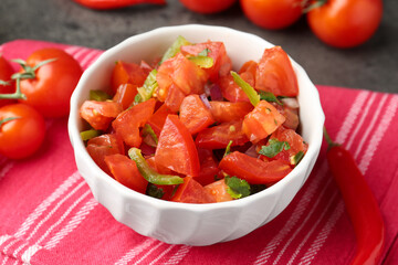 Delicious salsa (Pico de gallo) in bowl on grey table, closeup