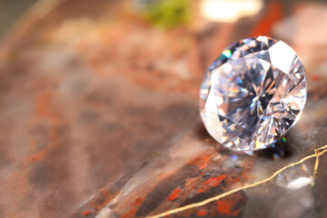 Beautiful shiny gemstone on brown marble surface, closeup. Space for text