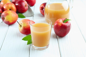Refreshing apple juice and fruits on white wooden table