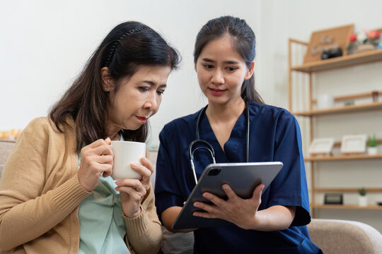 Caregiver showing health information on a tablet to an elderly patient