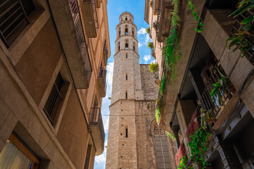 La Basílica de Pi cercana al mar, mas conocida como la Catedral del Mar, vista desde una calle próxima un día soleado con cielo azul y nubes. Desde la ciudad de Barcelona, Cataluña, España.