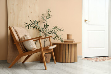 White door, armchair and wooden table near beige wall in interior of modern hall