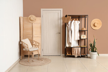 White door, folding screen and shelving unit near beige wall in interior of modern hall