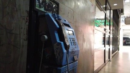 Closeup, vintage public phone, metallic obsolete retro machine inside 5th Avenue Gallery in Buenos Aires city, Argentina