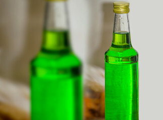 a bottle of melon flavored green syrup in the room. Selective focus, soft focus