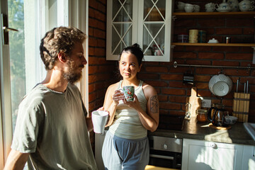 Couple enjoying morning coffee in sunny cozy kitchen