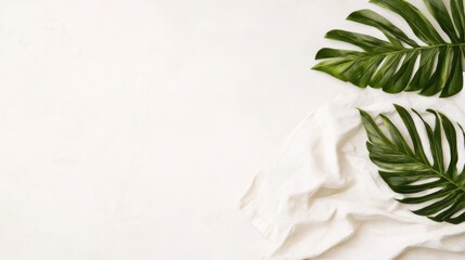 A soft white towel is elegantly adorned with two vibrant green leaves, creating a fresh and natural aesthetic.