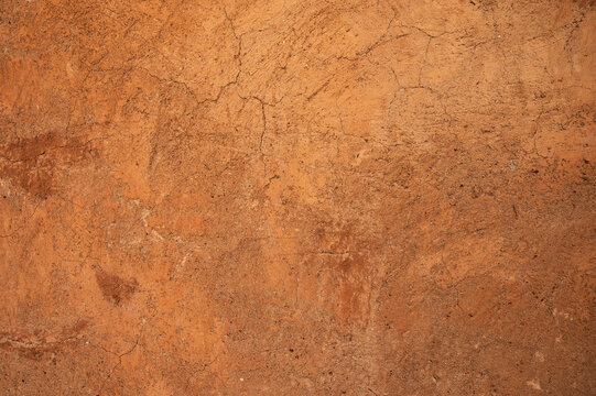 Full frame shot of an earthen wall texture of clay house structure. These walls are constructed by ramming a mixture of aggregates, including gravel, sand, silt and a small amount of clay.