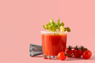 Glass of bloody mary with celery, lemon slice, tomatoes and measuring cup on pink background