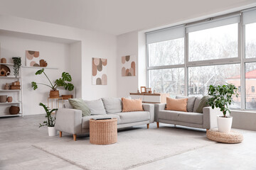 Interior of living room with comfortable sofas near window