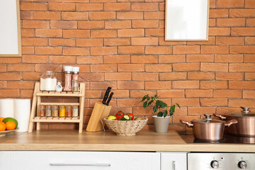 Stand with different spices, knives and vegetables on counter in kitchen