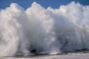 A large breaking weaves comes crashing down causing sky high spray and splash in a winter storm setting 