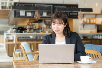 Fototapeta premium カフェで仕事をするビジネスウーマン