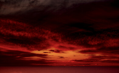 Dramatic sky filled with orange, red and various hues reflects against the Pacific Ocean horizon