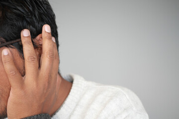 Man covering ears while experiencing loud noise in quiet room