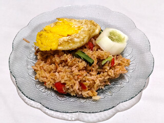 Fried rice, vegetables, crackers with fried egg as a side dish. Fried rice on a glass plate.