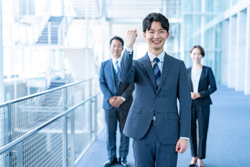 オフィスでガッツポーズをする若手のビジネスマン